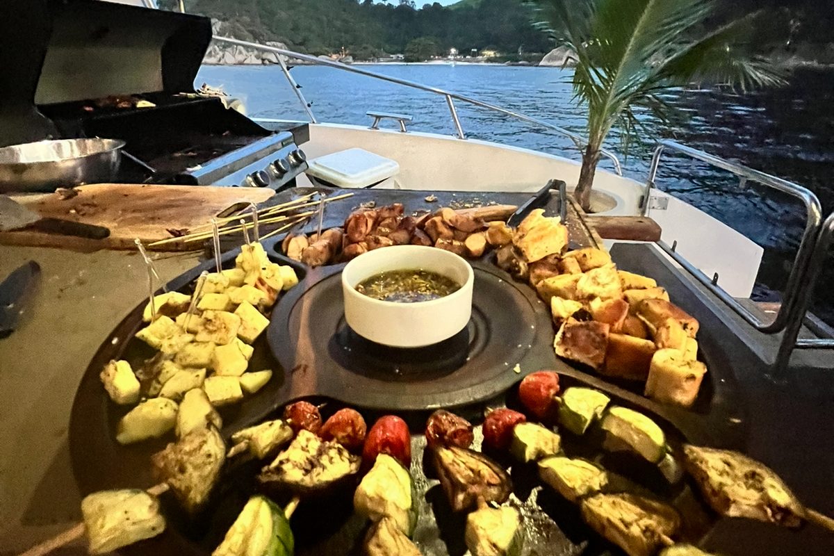 Churrasco com espetinhos preparado a bordo, com vista para o mar