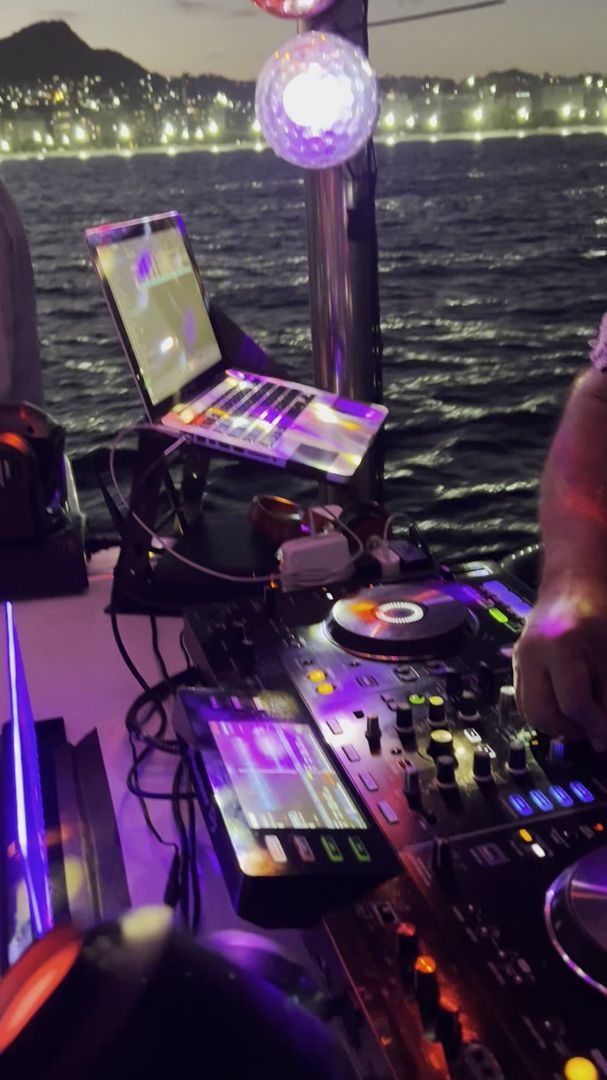 DJ e pista montados a bordo, com o Rio de Janeiro iluminado ao fundo