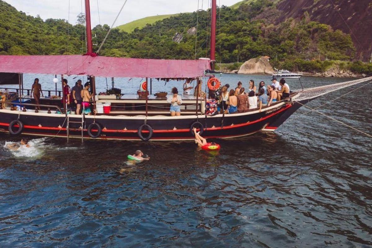 Grupo grande a bordo de escuna da Vivere, com pessoas na água