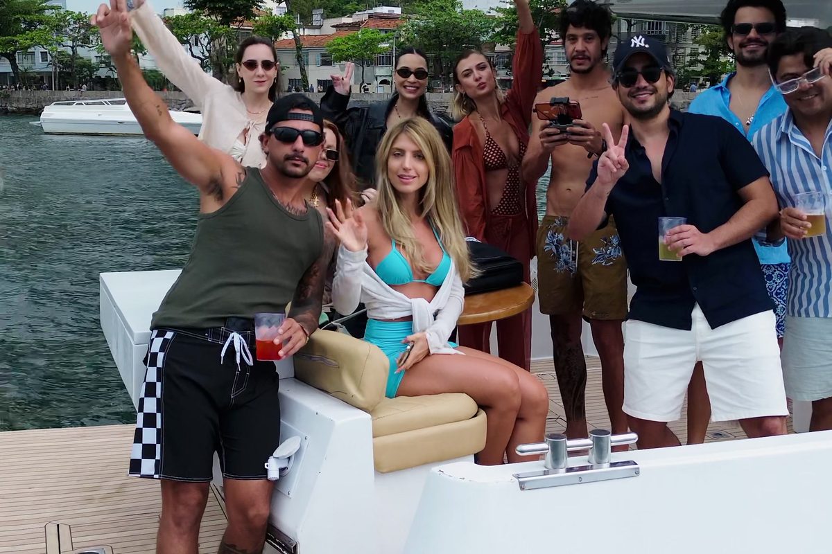 Grupo a bordo na popa de uma lancha da Vivere, com o Pão de Açúcar ao fundo